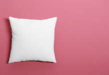 9 Tips & Tricks to Help Babies Sleep Through the Night for Sleep-Deprived Parents White pillow on a pink background