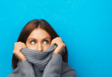 Woman looks embarrassed hiding in her turtleneck.