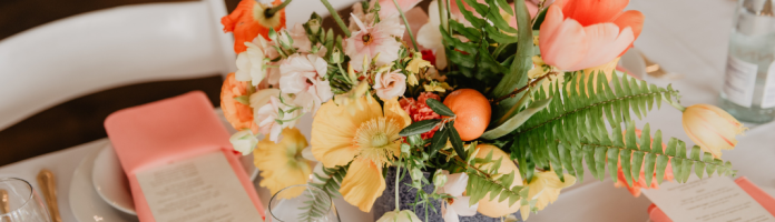 A bouquet of flowers sits on a table with place cards.