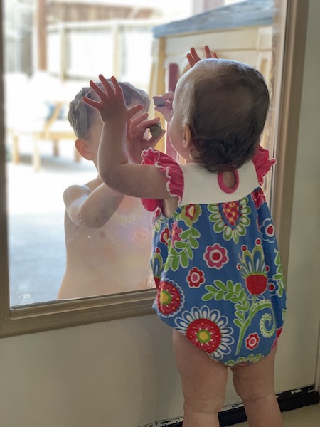 toddler boy and baby girl playing together