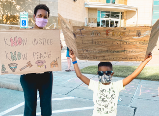 black mom and black child holding protest signs