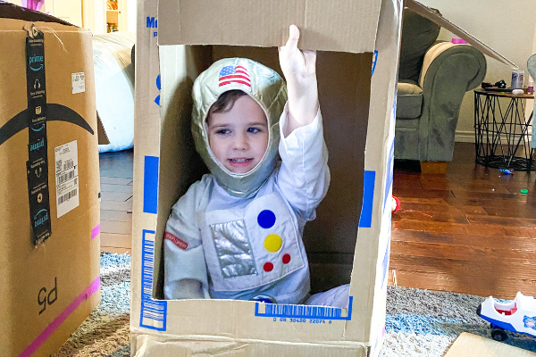 kids playing dress up in cardboard boxes