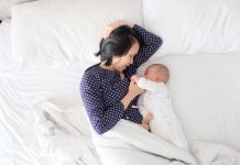 Mother has breastfeeding struggles while laying in bed with baby.