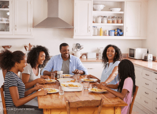 Family with teens sits at their dinner table.