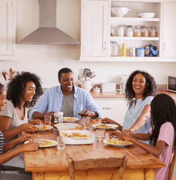 Family with teens sits at their dinner table.