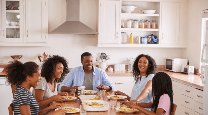 Family with teens sits at their dinner table.