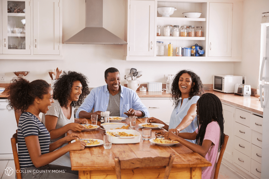 Family with teens sits at their dinner table.