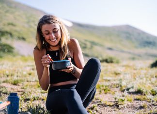 Teenage girl eats a meal outside.