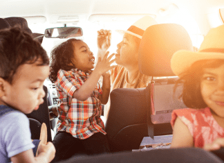 Mom with three kids in a car going on a road trip for staycation Collin County