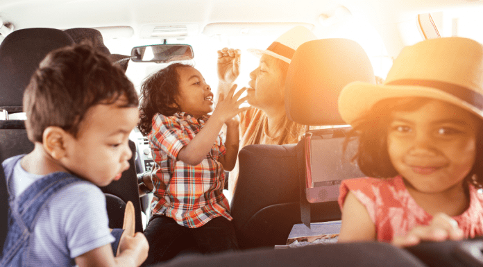 Mom with three kids in a car going on a road trip for staycation Collin County