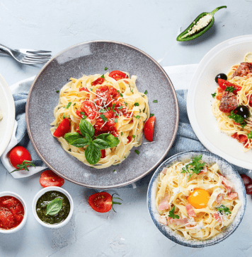 A table is set with different pasta dishes from carbonara to spaghetti with mussels.