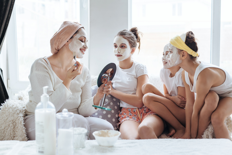 Mom and tweens and teens do a face mask together.