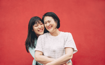 Mom and tween daughter embrace and smile