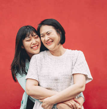 Mom and tween daughter embrace and smile