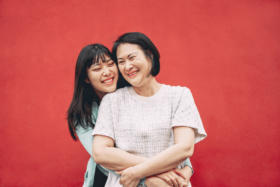 Mom and tween daughter embrace and smile