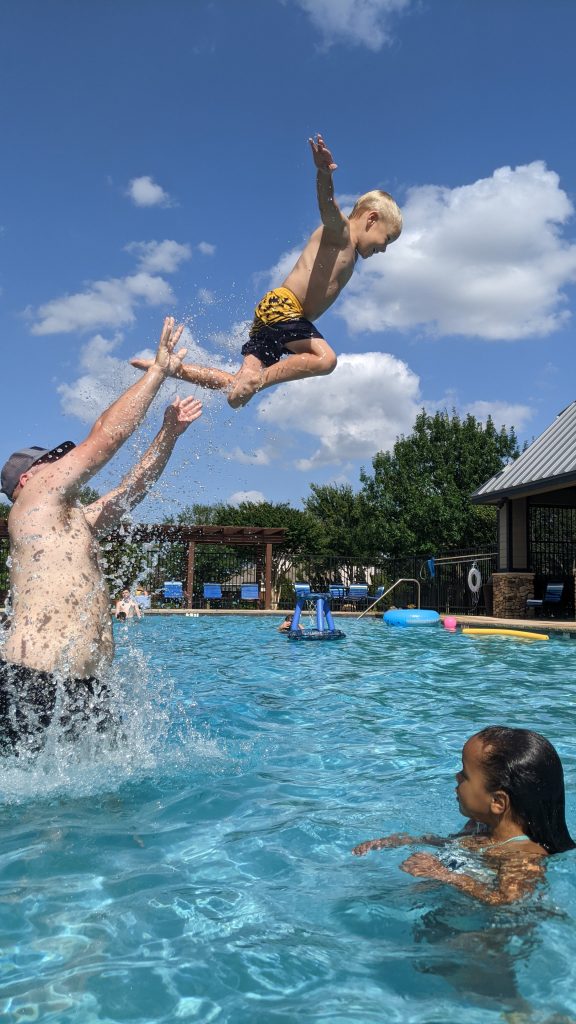 child being launched by dad in pool, summer photo prompts
