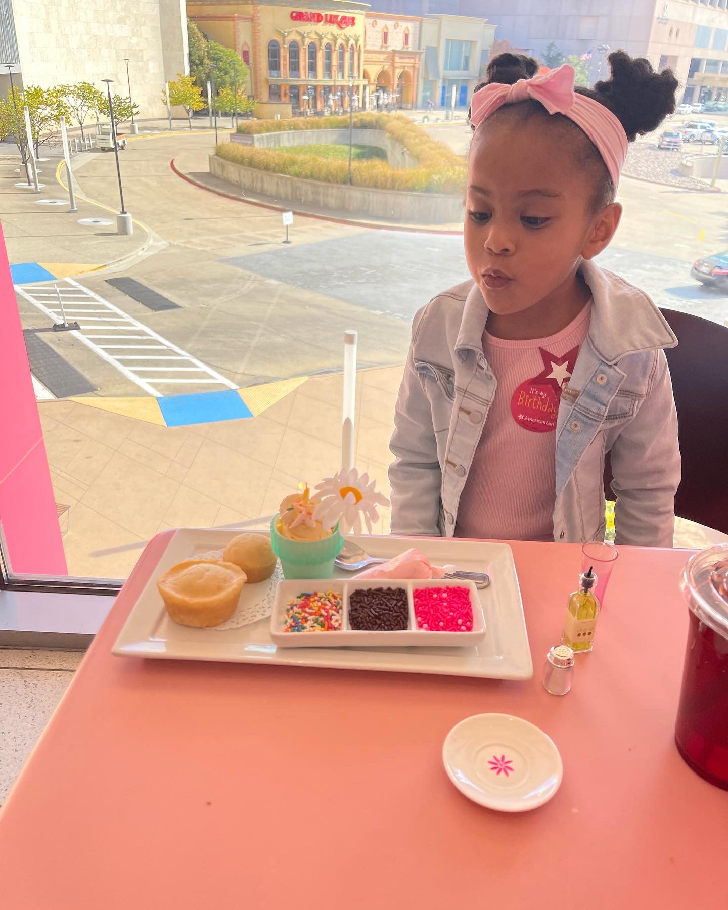 birthday girl blowing out candle at the American Girl Bistro in Dallas