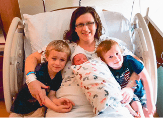 mom with newborn and children in hospital bed