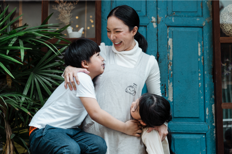 Laughing mom hugging kids