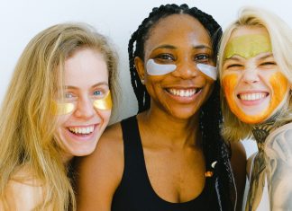 3 women smiling while doing eye masks, how to beat the winter blues