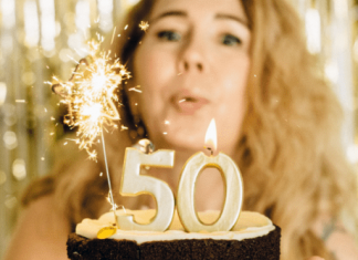 woman blowing out birthday 5-0 birthday candles, best things about turning 50