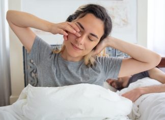 woman waking up with a stretch, how to wake up at 5am