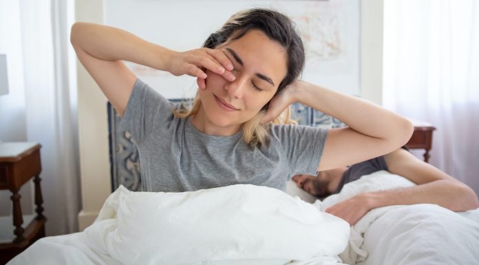 woman waking up with a stretch, how to wake up at 5am