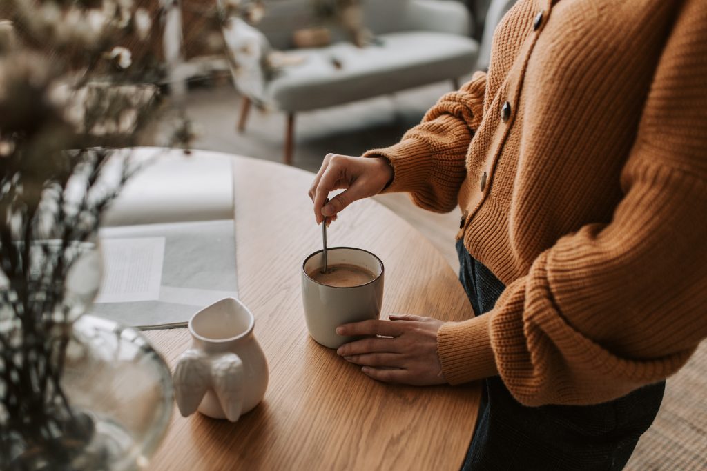 woman stirring coffee, how to wake up at 5am