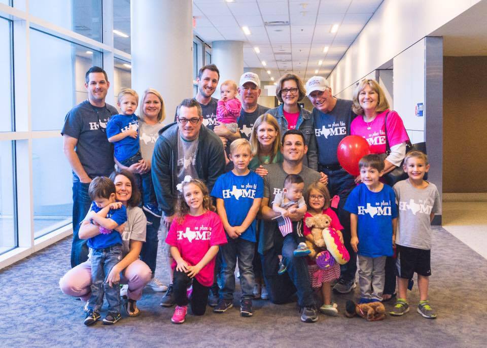 large smiling group at the airport, post-adoption depression story