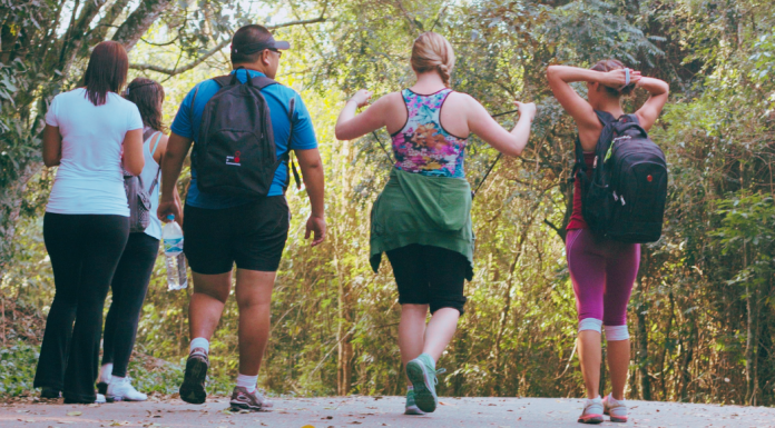 group of people walking on a trail from behind, benefits of walking more