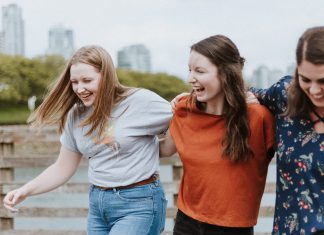 laughing women with linked arms, what is my attachment style