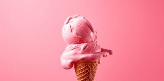 strawberry ice cream cone floats on a pink background