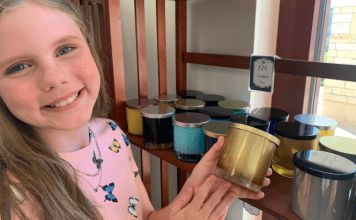 girl smiling and holding a candle at Rocky Creek Candle Company