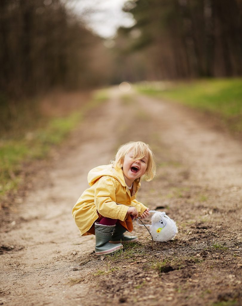 child laughing on muddy trail