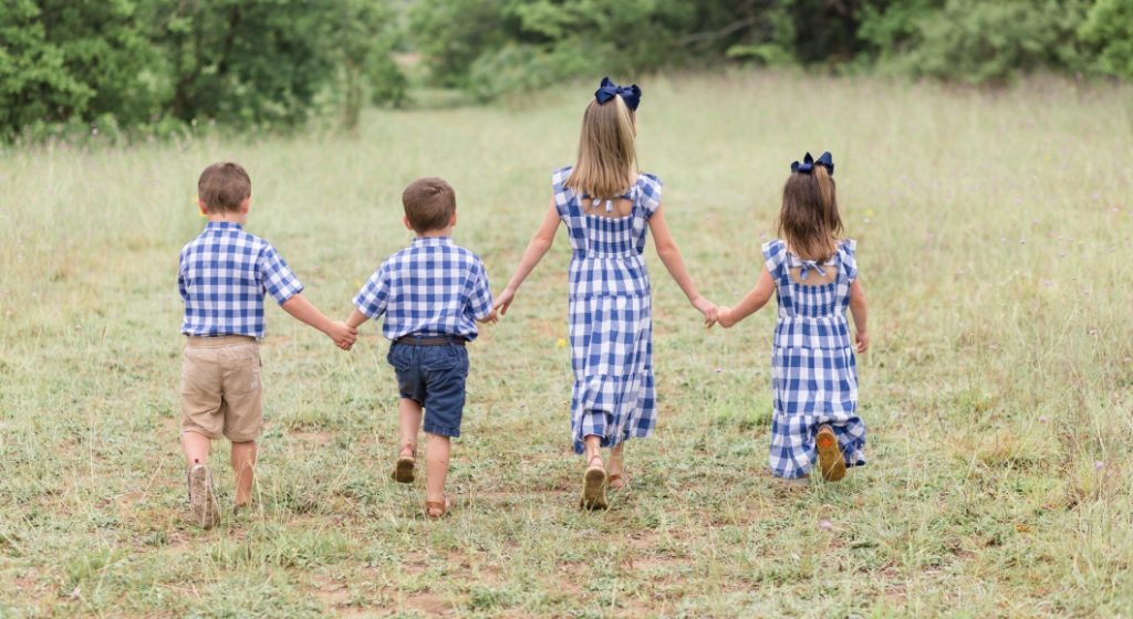 Four siblings hold hands.