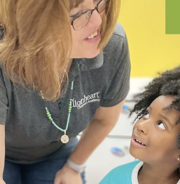 Teacher and young student smiling together at Lionheart Children's Academy