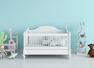 A crib in a blue room is a newborn essential.