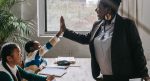 Adult gives elementary age child a supportive high five