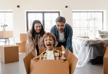 Mom and dad push their son in a moving box for fun