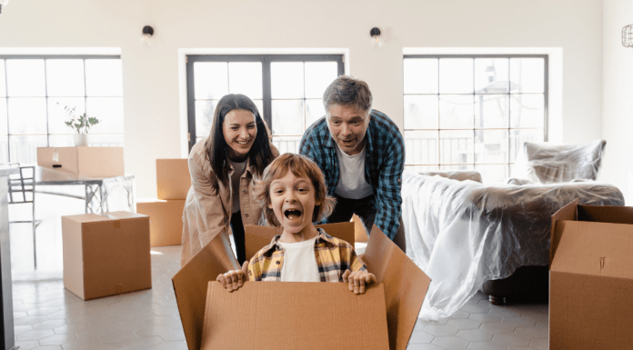 Mom and dad push their son in a moving box for fun