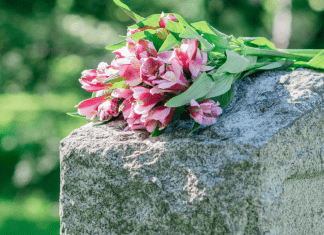 Flowers rest on top of a headstone.