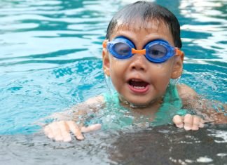 Young child with goggles swimming