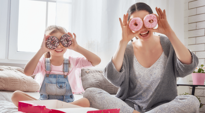 A mom and daughter put donuts on their eyes.