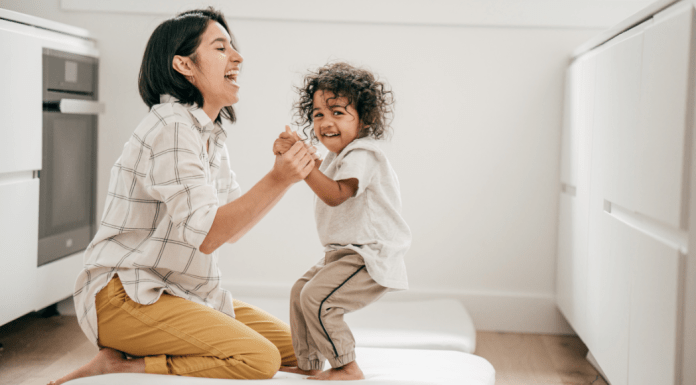 A mom sits on the floor with her toddler son.