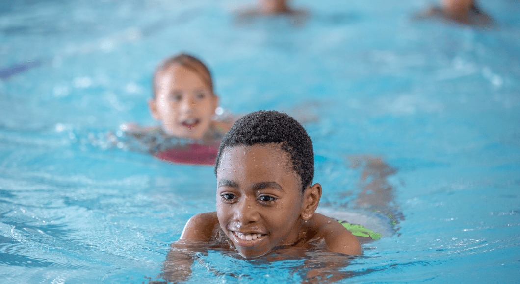 Kids swim in a pool.