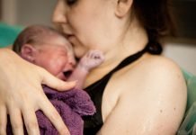 mother and baby in tub after natural birth in birthing center