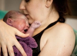 mother and baby in tub after natural birth in birthing center