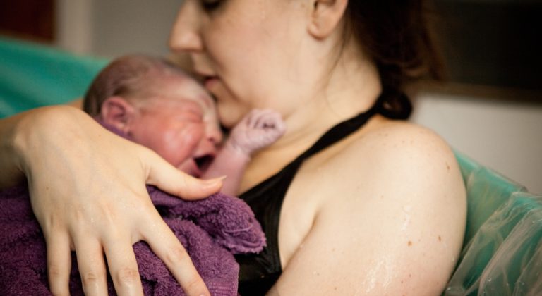 mother and baby in tub after natural birth in birthing center