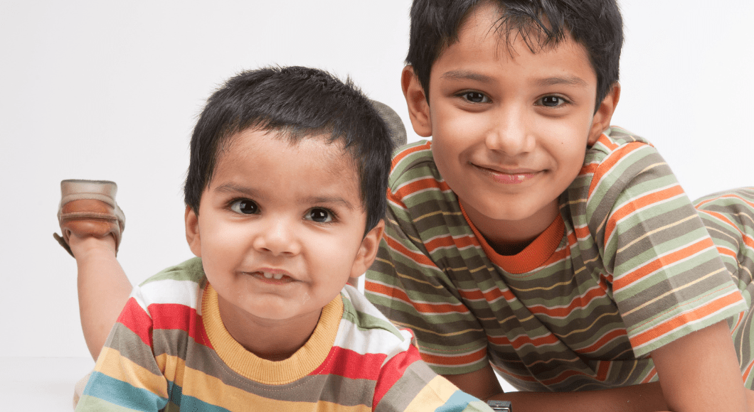 Two brothers smile at the camera.