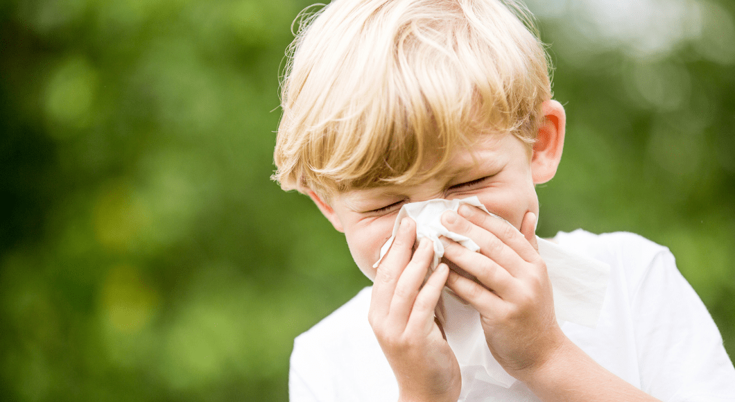 A child sneezes into a tissue.